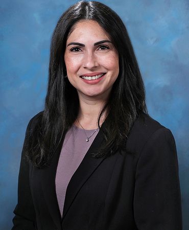 Smiling woman in a white lab coat.