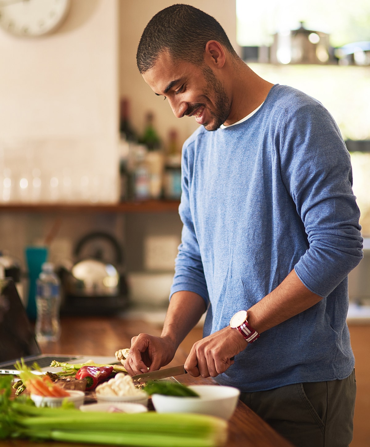 Man chopping vegetables in a kitchen setting.