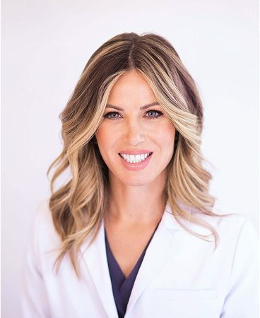 Smiling woman in a white lab coat.