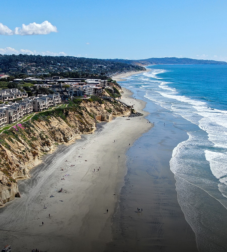 Aerial view of a coastal city and highway.
