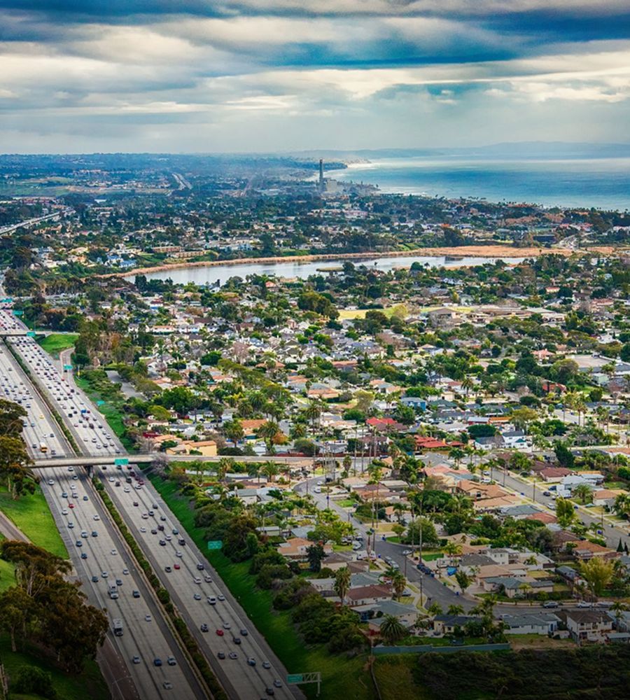 Aerial view of coastal city and highway.