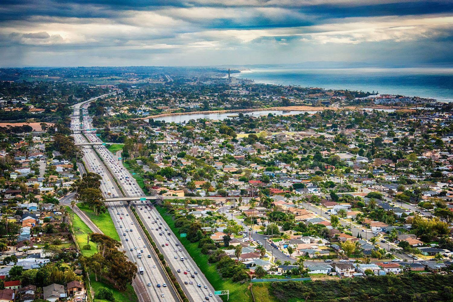 Aerial view of highway and coastal suburban area.