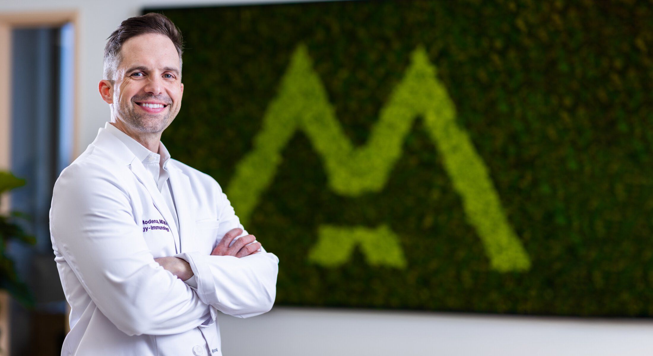 Doctor smiling in a modern clinic setting.