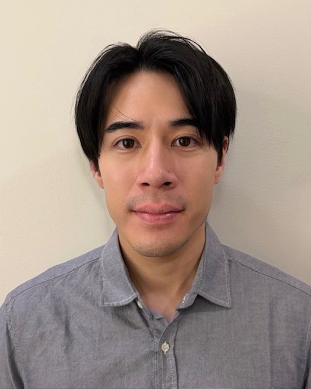 Person with dark hair wearing a gray shirt.