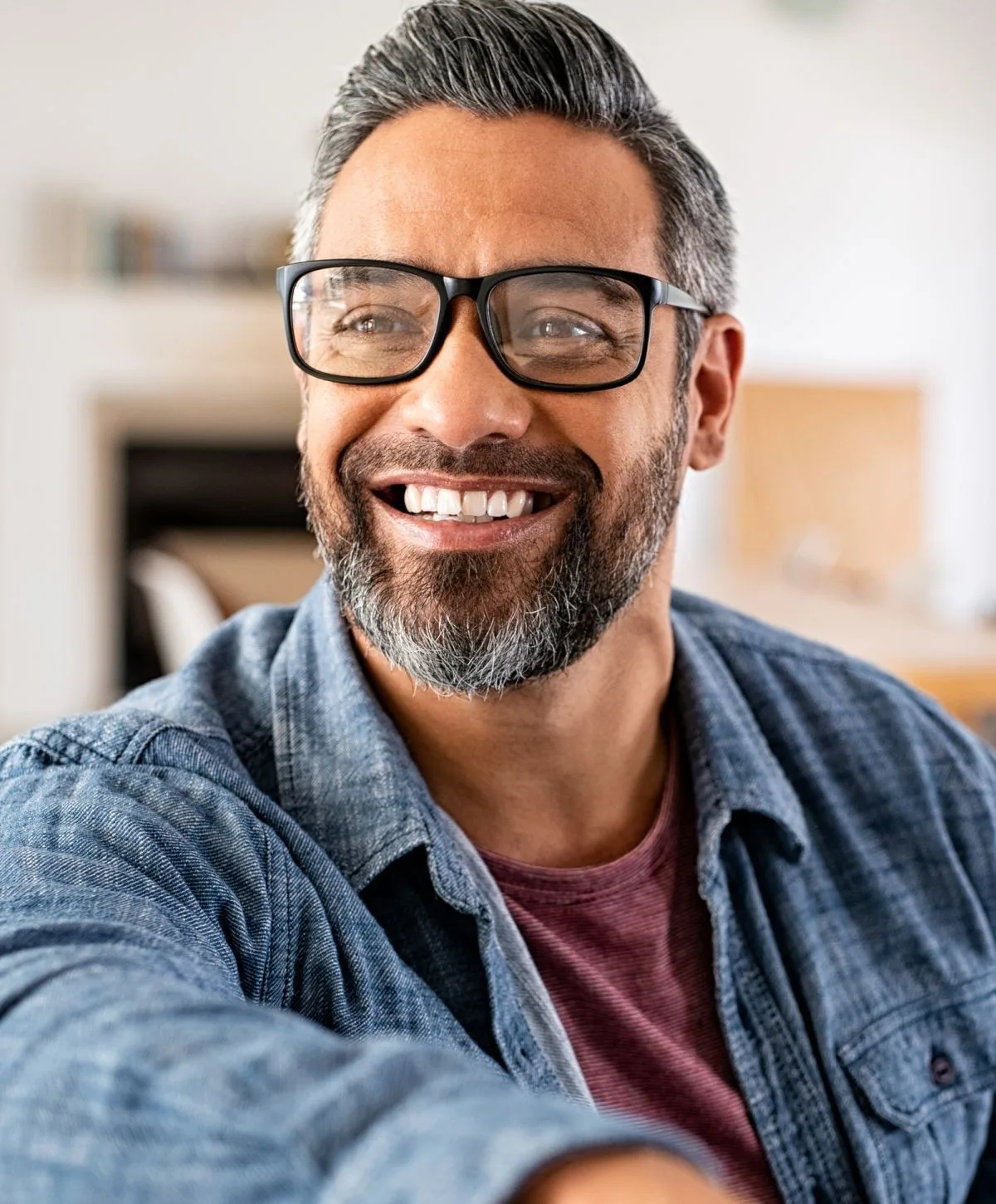 Smiling man wearing glasses and casual clothing.