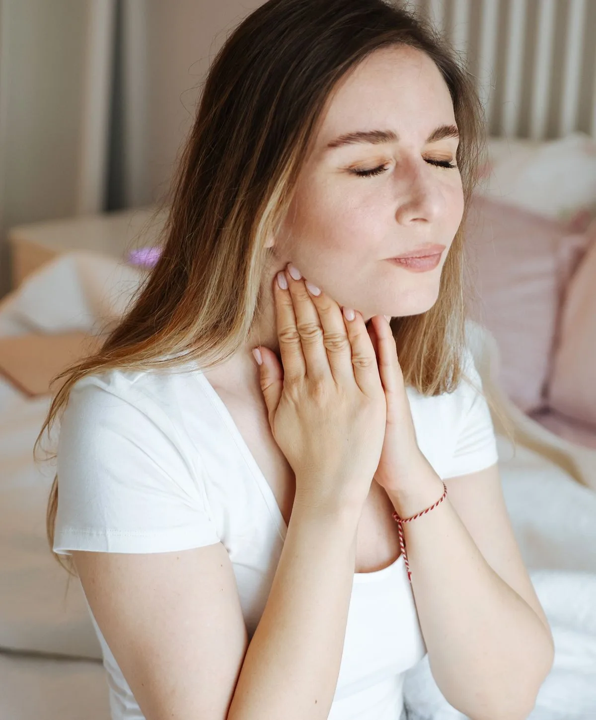 Woman touching the side of her neck.