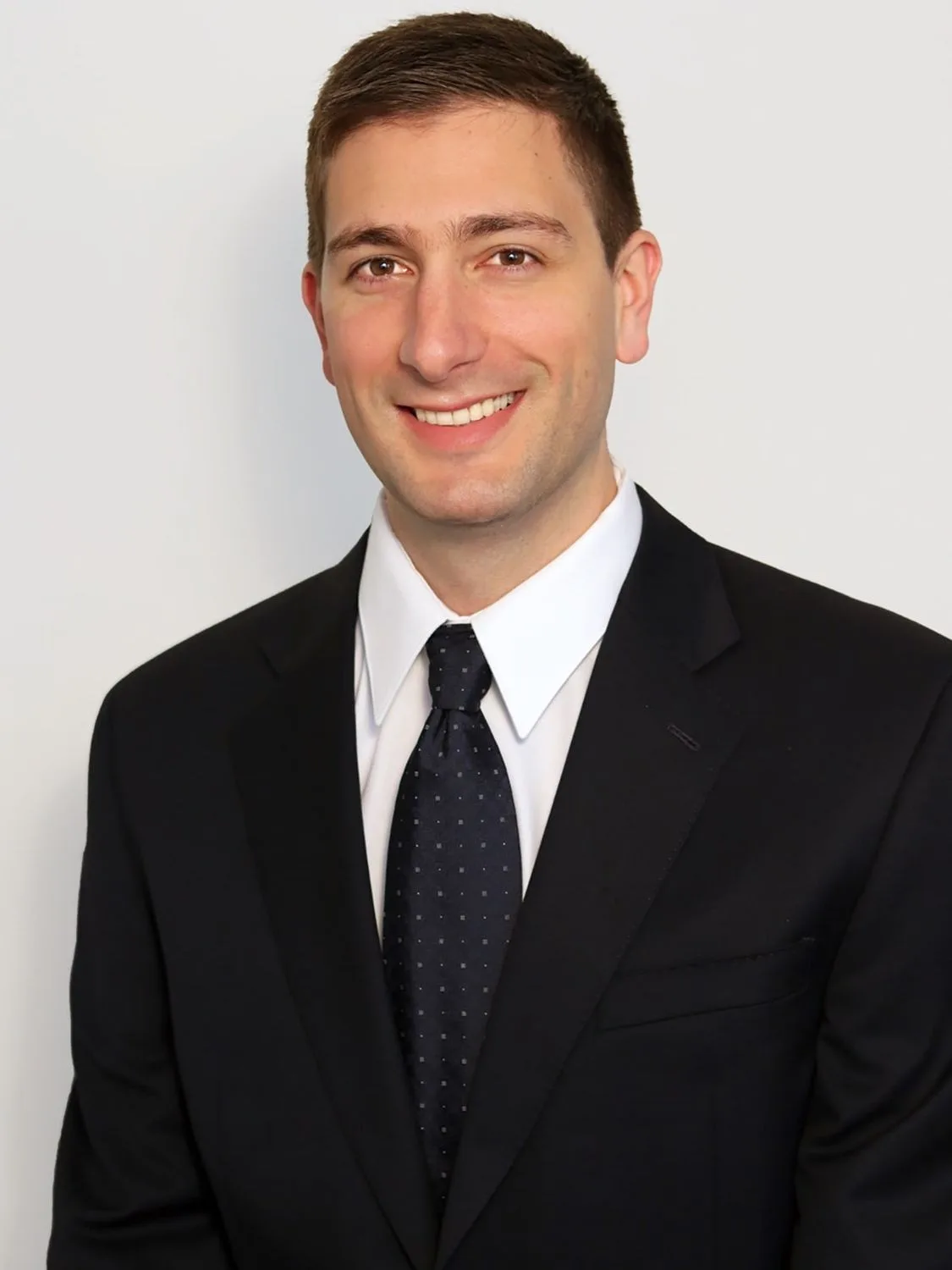 Professional man in suit and tie smiling.