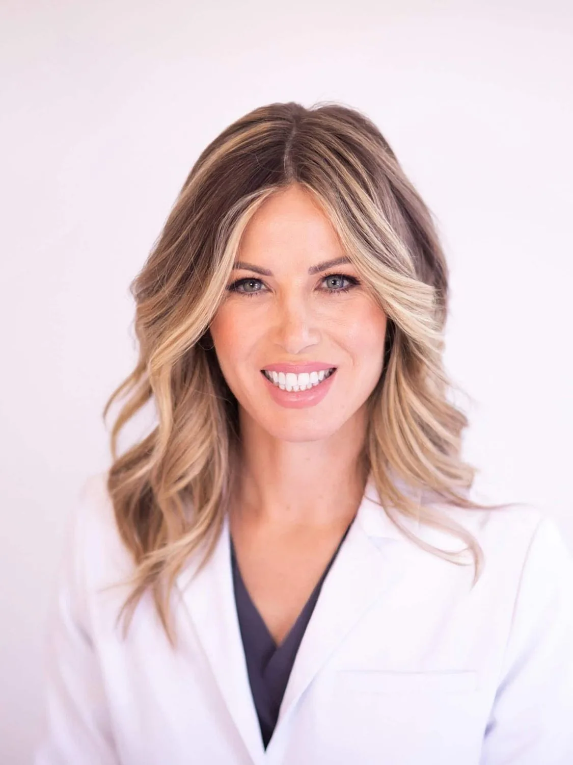 Female doctor smiling in professional attire.