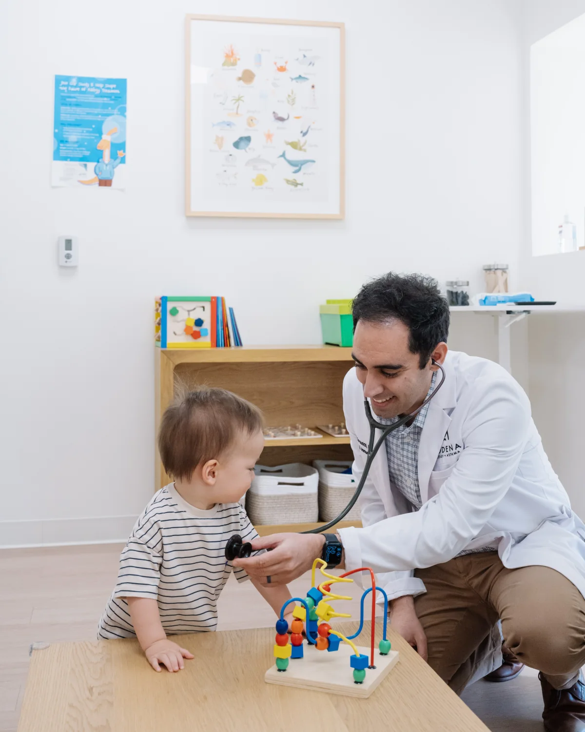 Dr. Ali Doroudchi examining a young child with a stethoscope.