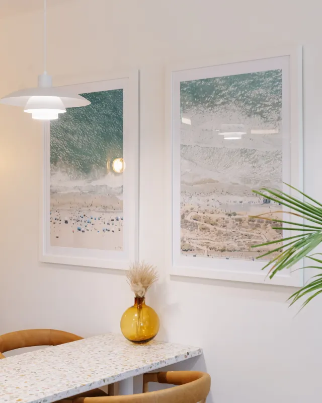 Framed aerial beach artwork above a table in the Solana Beach office.
