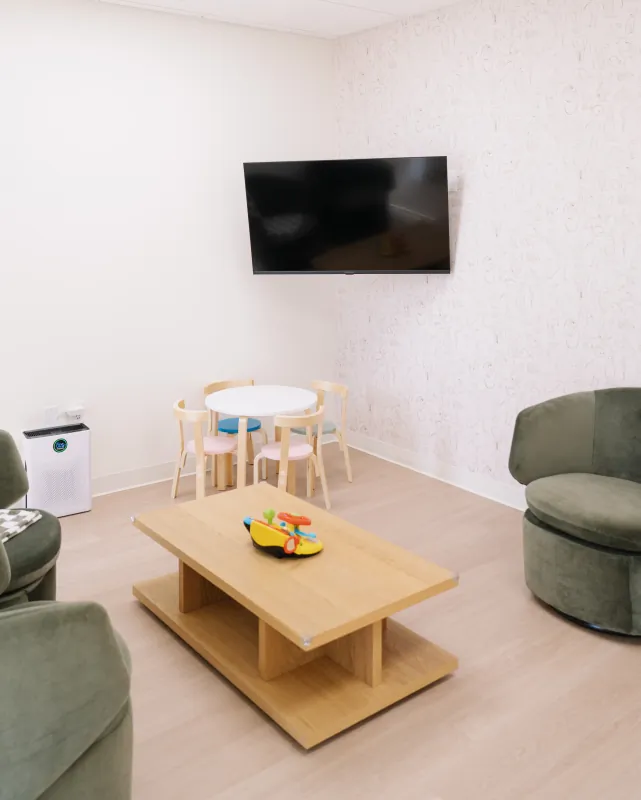 Children's table, television, and animal-patterned wall in the Solana Beach waiting room.