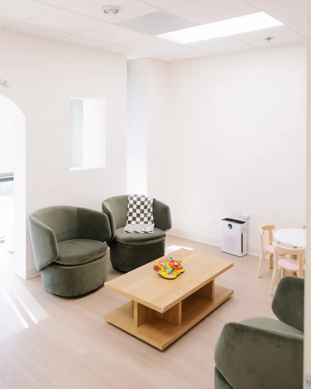 Pediatric waiting room with green lounge chairs and a children's table at the Solana Beach office.