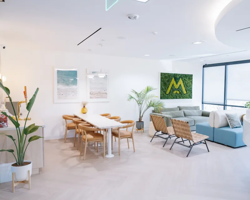 Wide view of the Solana Beach waiting lounge, seating, and communal table.