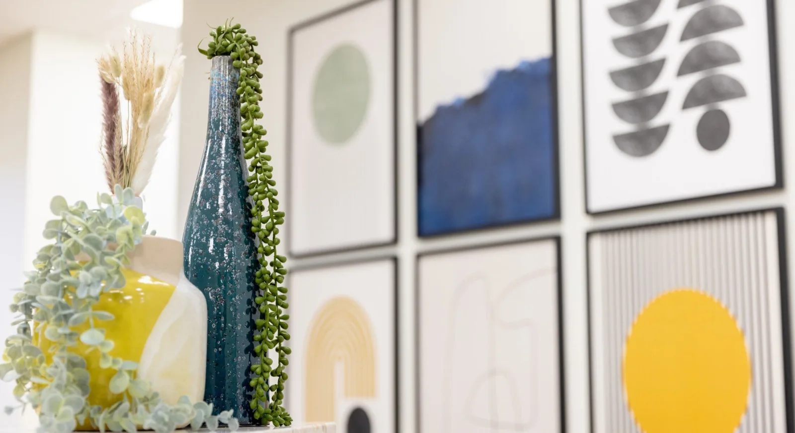 Decorative vases and wall art in modern setting.