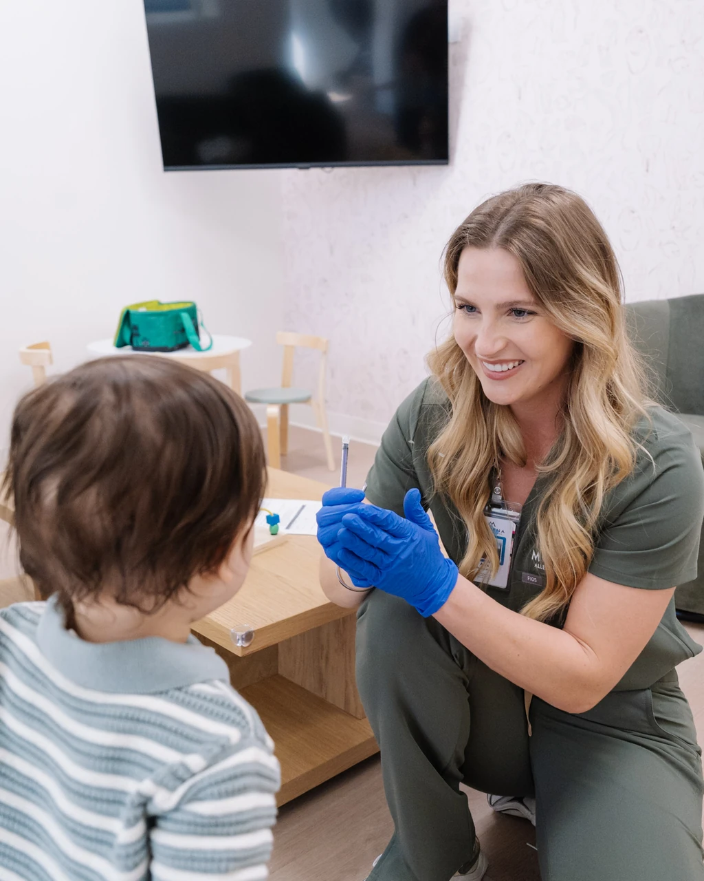 Clinician talking with a child during an allergy consultation.