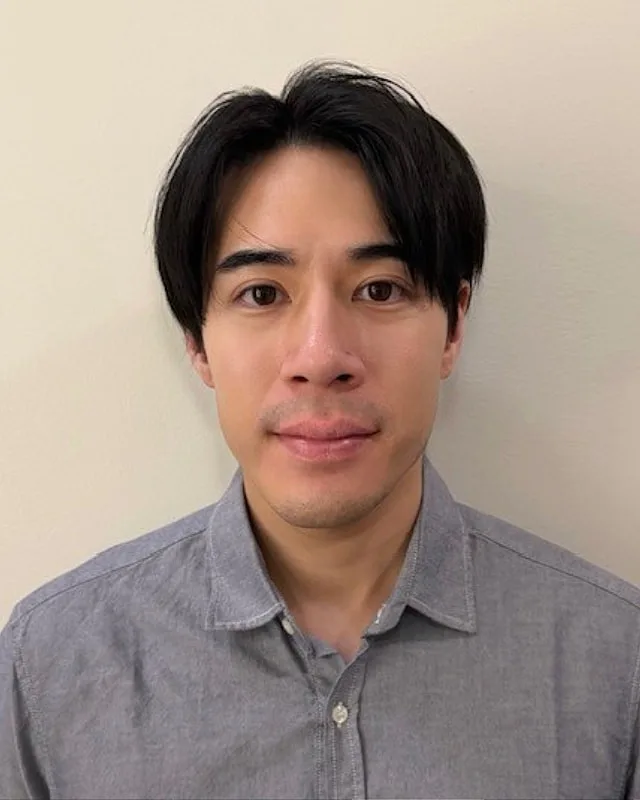 Person with dark hair wearing a gray shirt.