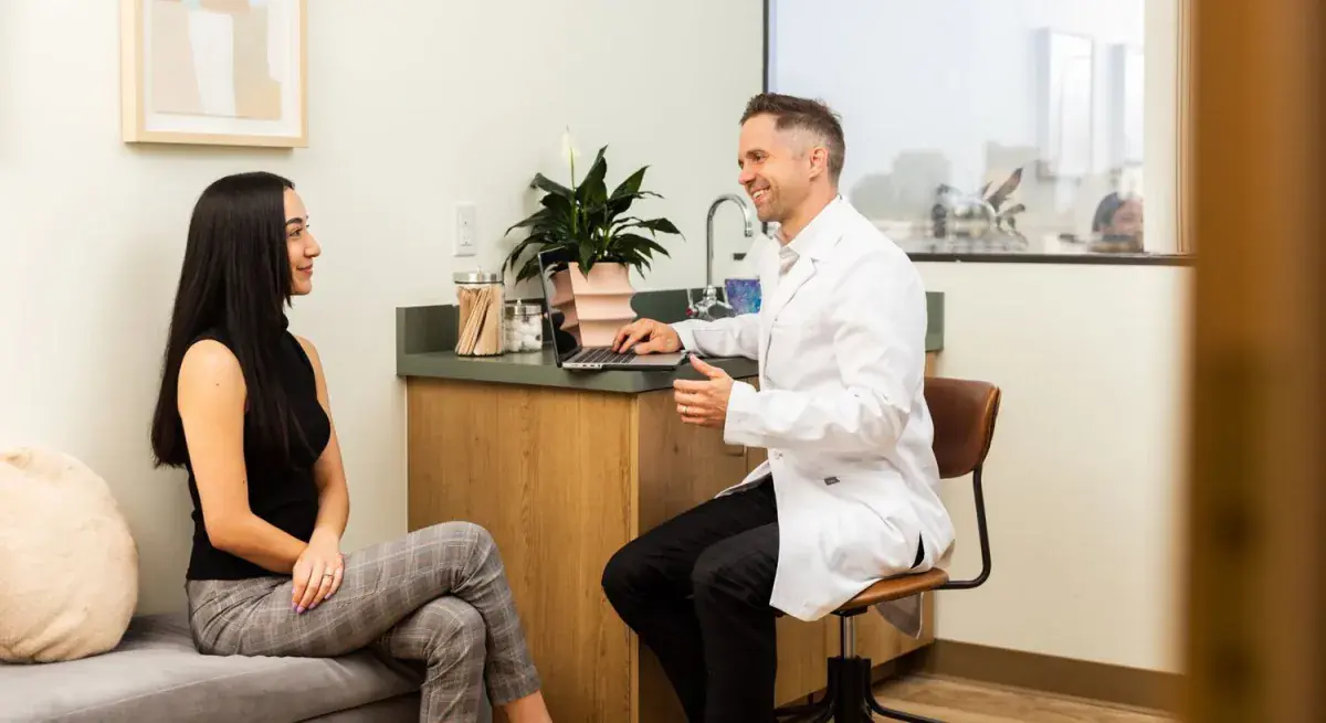 Modena Health physician speaking with a patient in an exam room.
