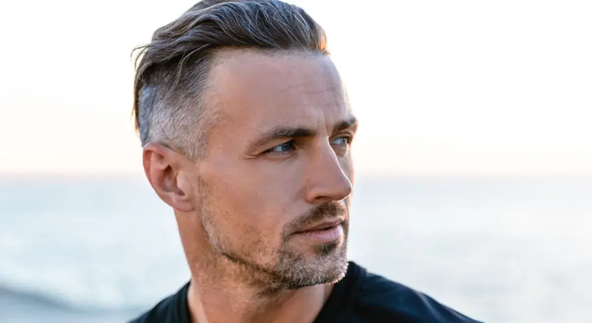 Man with stylish haircut by the beach.