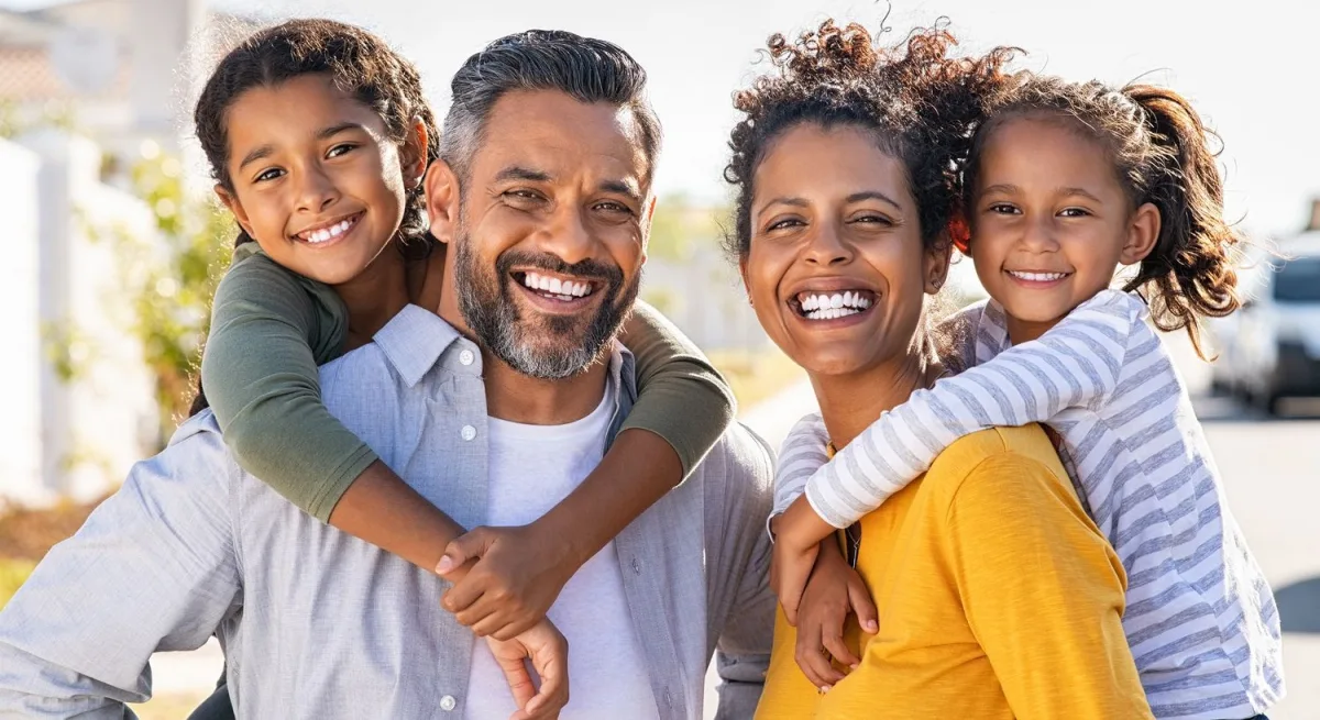 Happy family posing outdoors, smiling together.