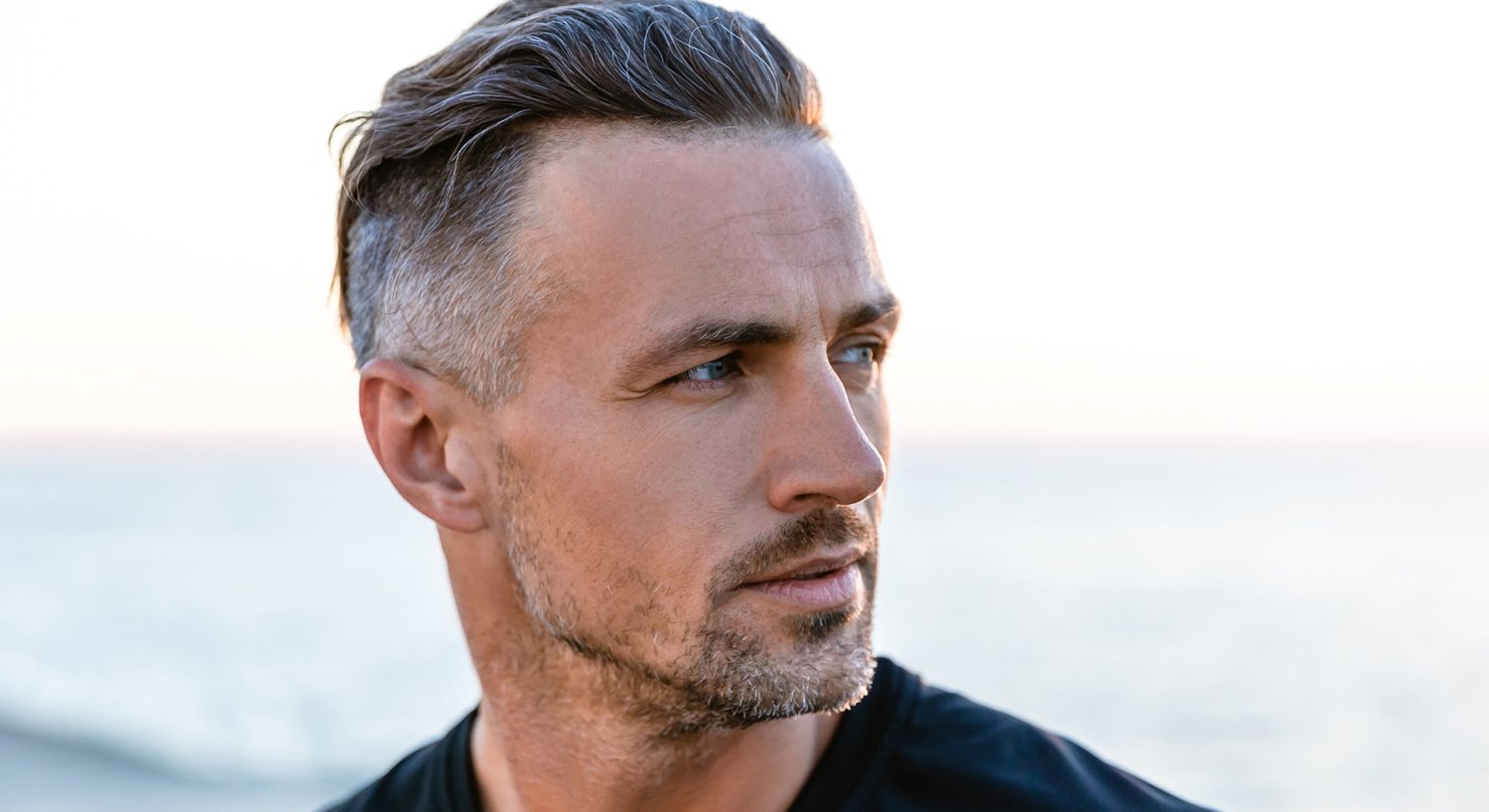 Man with stylish haircut by the beach.